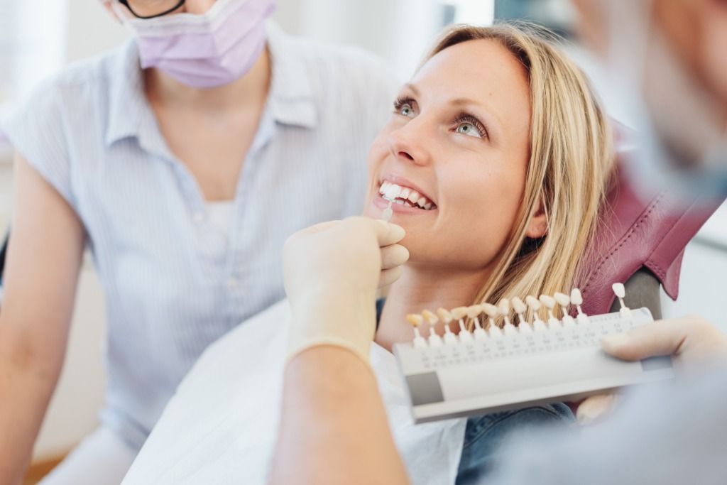 dentist checking the whiteness of a patients teeth picture id1251515365