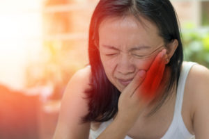 woman hand on cheek face as suffering from facial pain or toothache