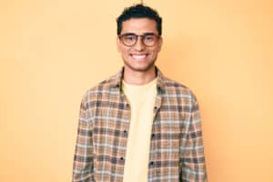 Handsome Latino man flashes a complete smile after getting a CEREC dental crown